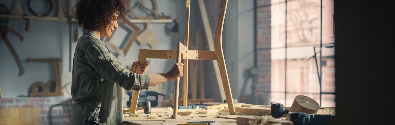 Small business worker builds a chair in woodshop