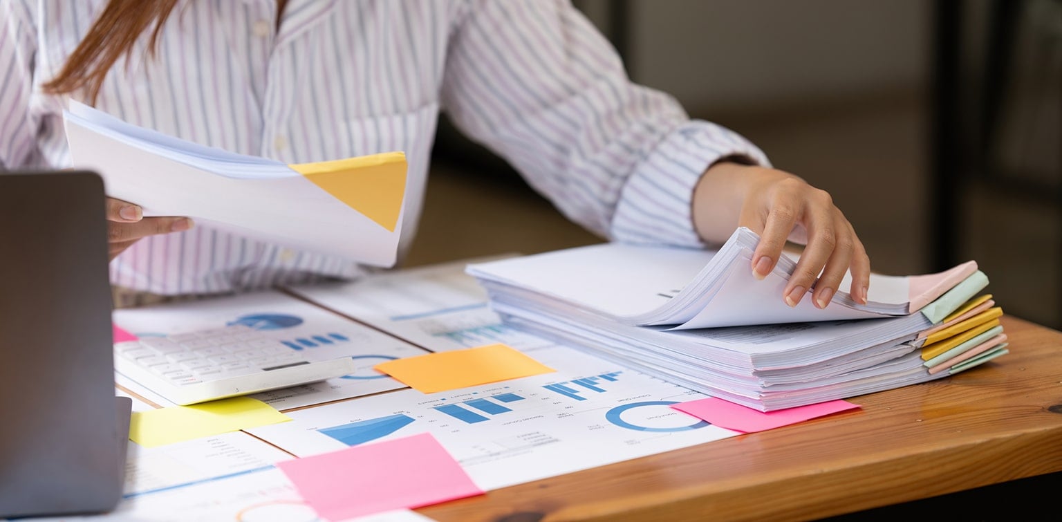 Female business owner reviewing stack of organized financial files