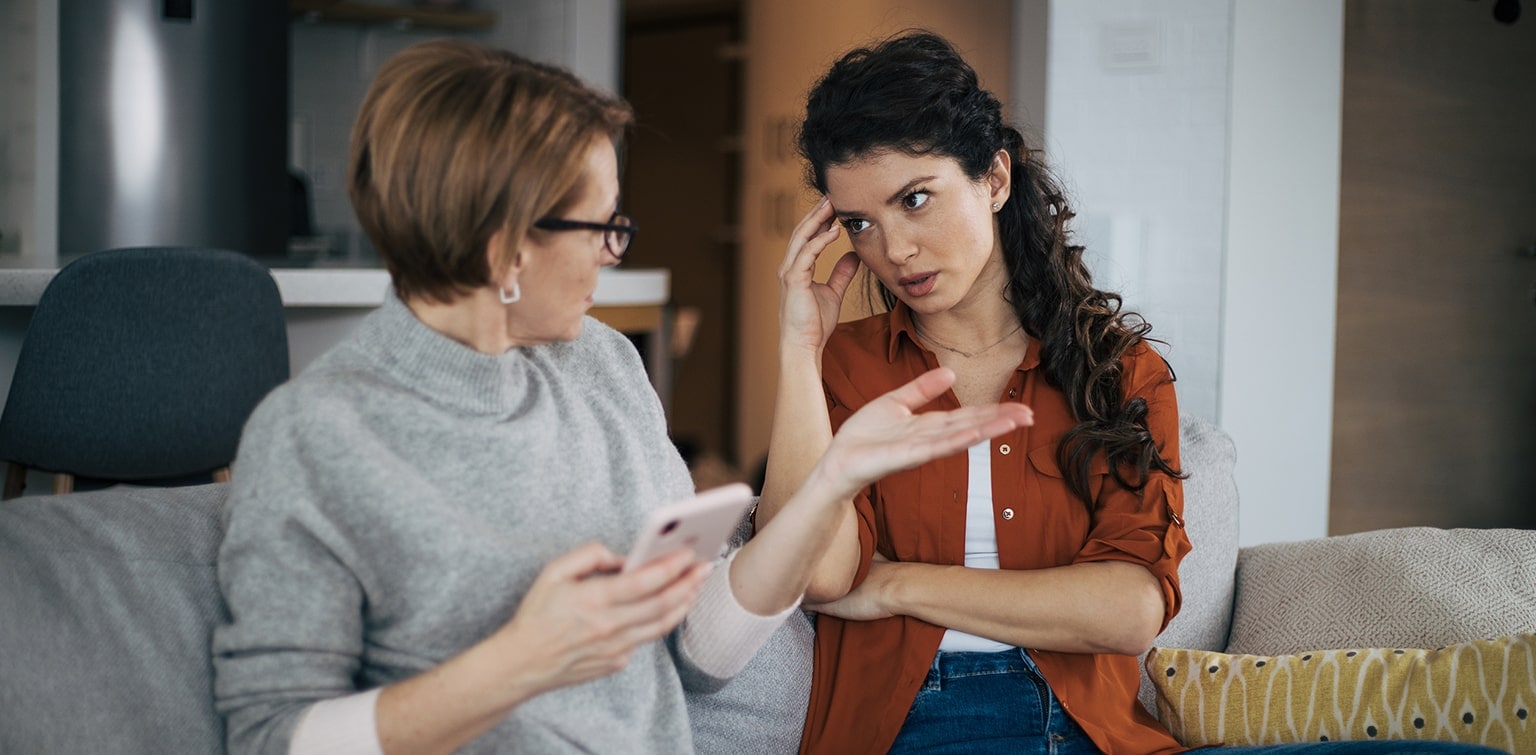 Mother and daughter engaged in convrsation on a couch as they exchange ideas about financial planning