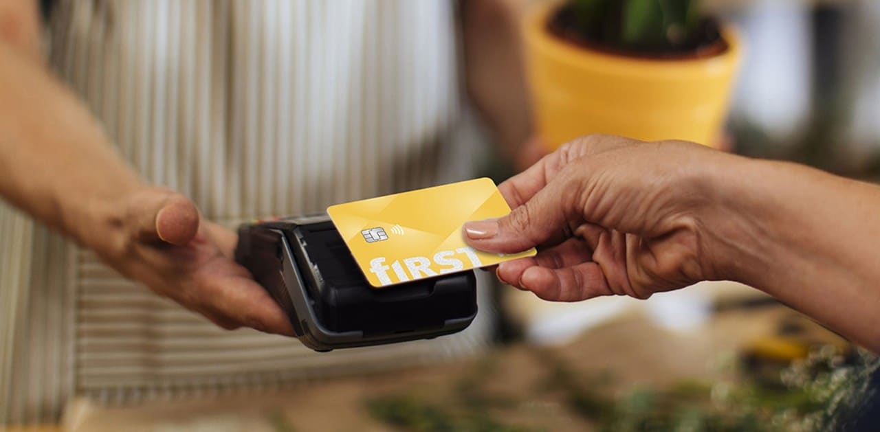 Woman using contactless First Financial debit card for payment at florist